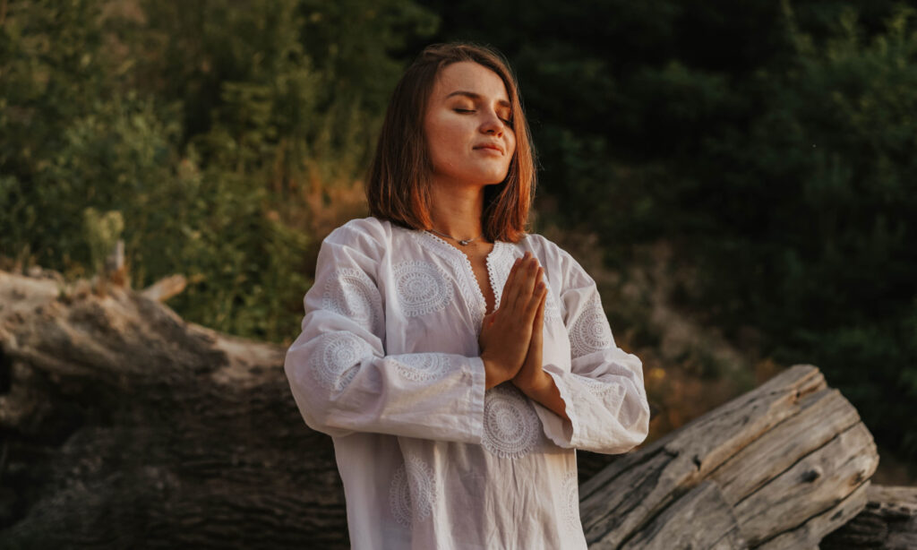 woman outside breathing, praying, and connecting with the divine