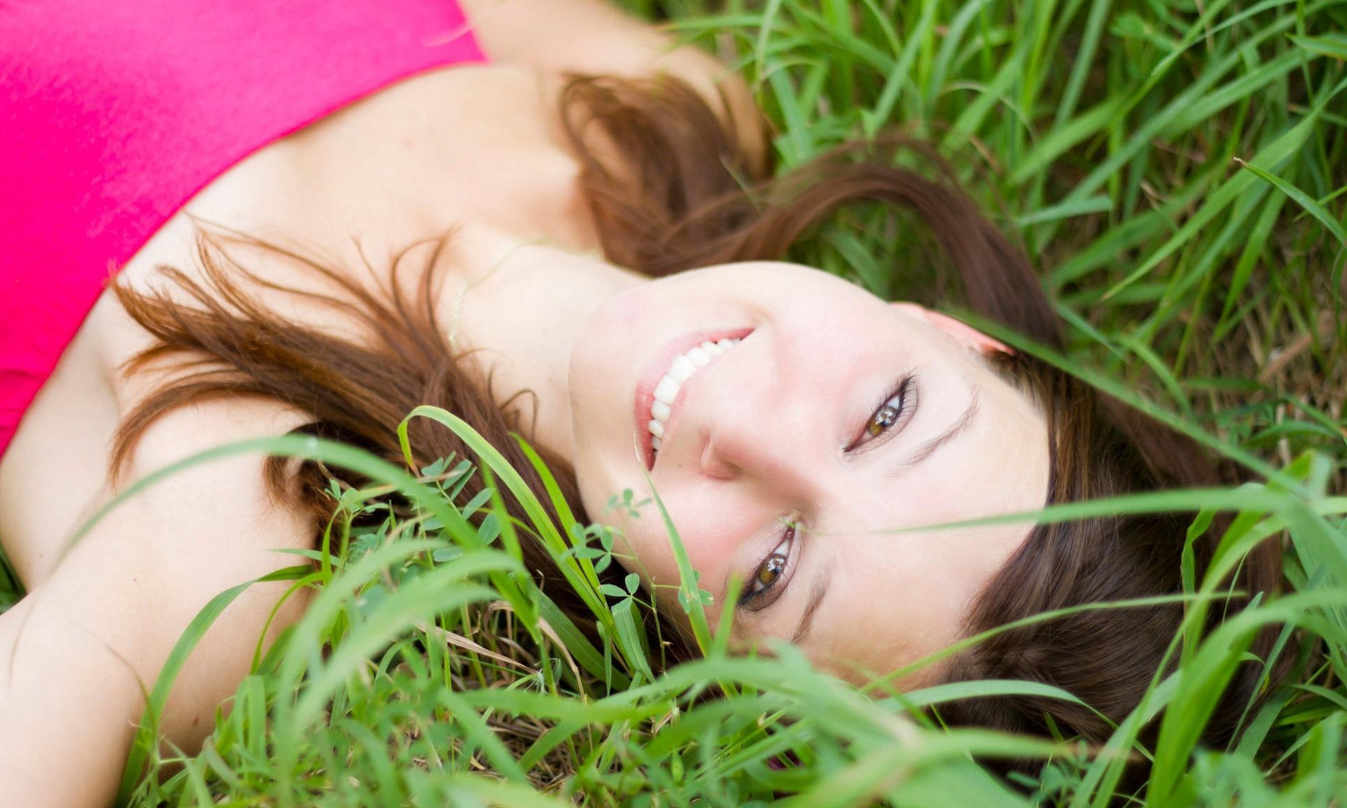 woman lying in the grass, slowing down to appreciate the natural rhythms of of life.